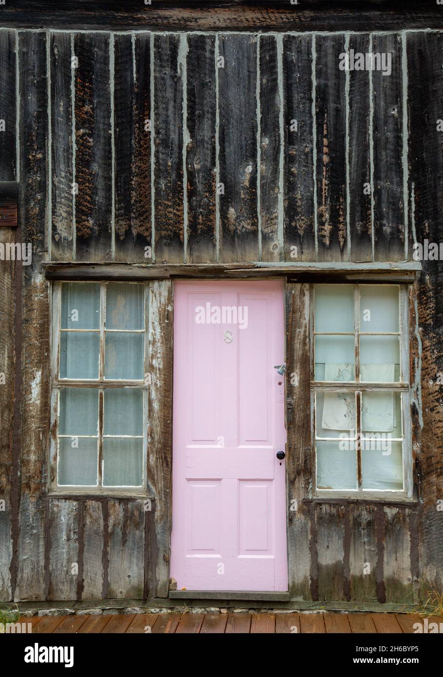 A vertical shot of a pink door of an old wooden house in a ghost town in Colorado, USA Stock Photo