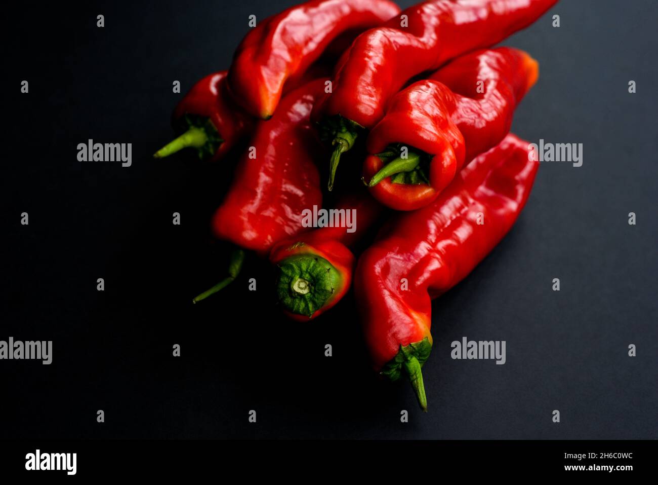 Fresh red sweet peppers isolated on black background Stock Photo - Alamy