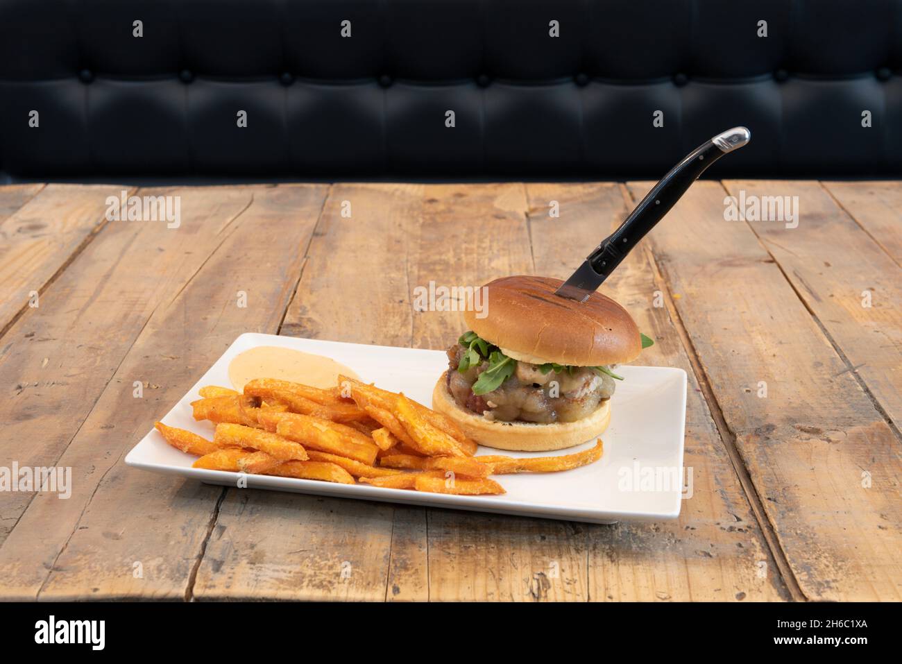 Beef burger with melted cheese, goat cheese, arugula leaves, salsa and