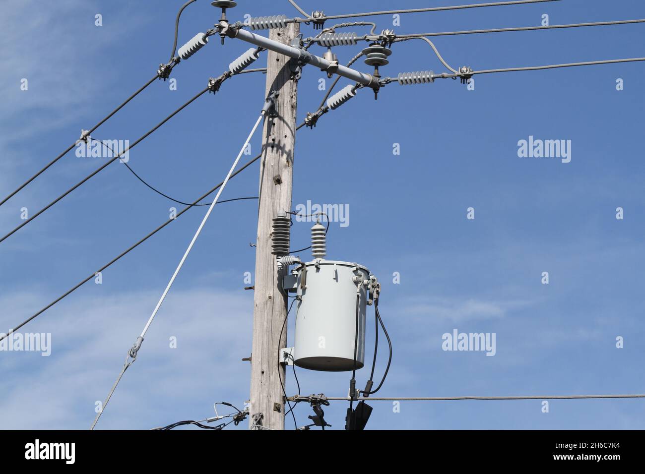 Electrical high voltage power line and electrical drums on wood pole Stock Photo