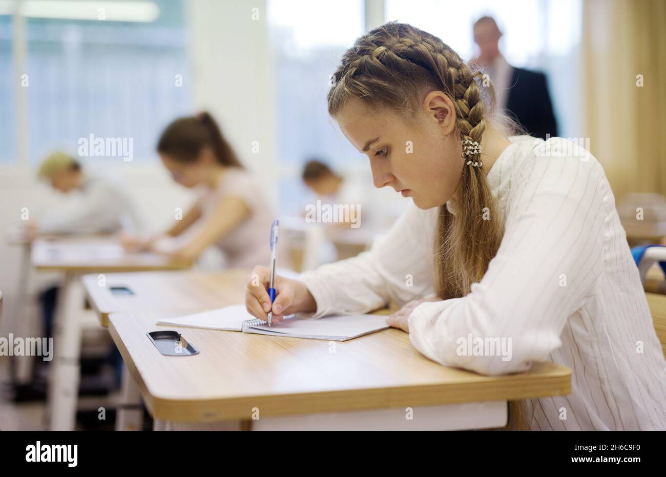 Teen girl sitting at desk in classroom Stock Photo - Alamy