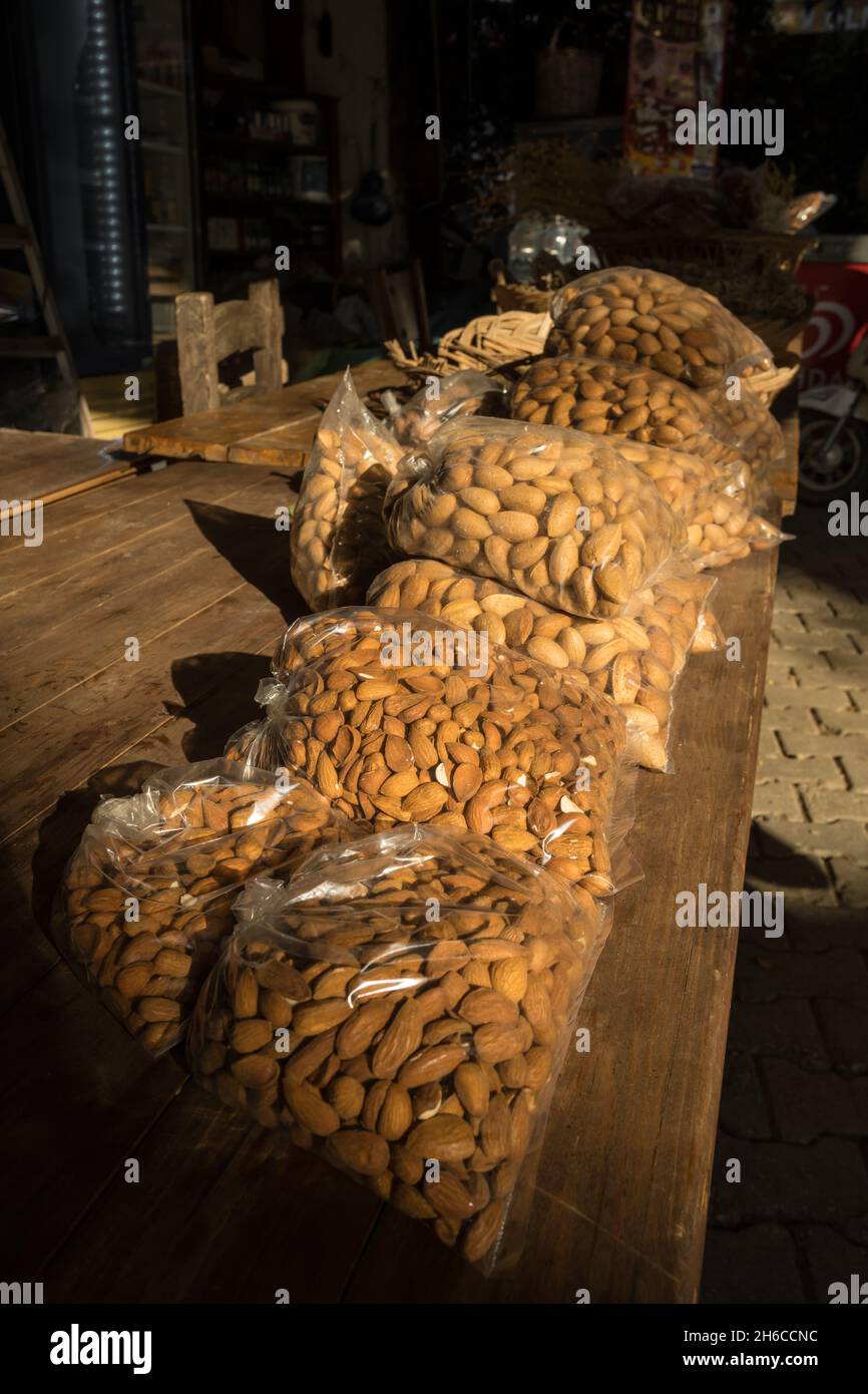 Packed almond nuts for sale on the wooden table in retail shop Stock Photo