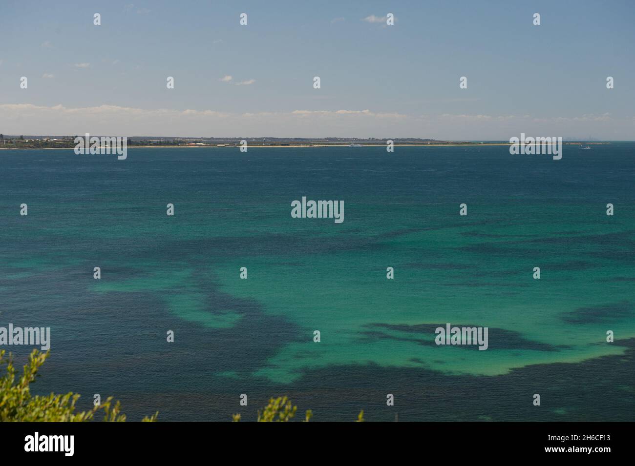 A distant view of the Bellarine Peninsula across the green waters of Port Phillip Bay from Point Nepean in Victoria, Australia. Stock Photo