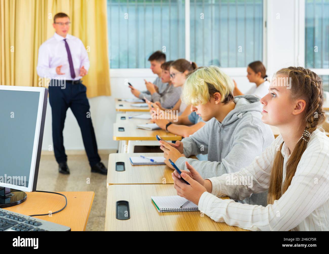 Schoolchildren with mobile phones in informatics lesson Stock Photo - Alamy