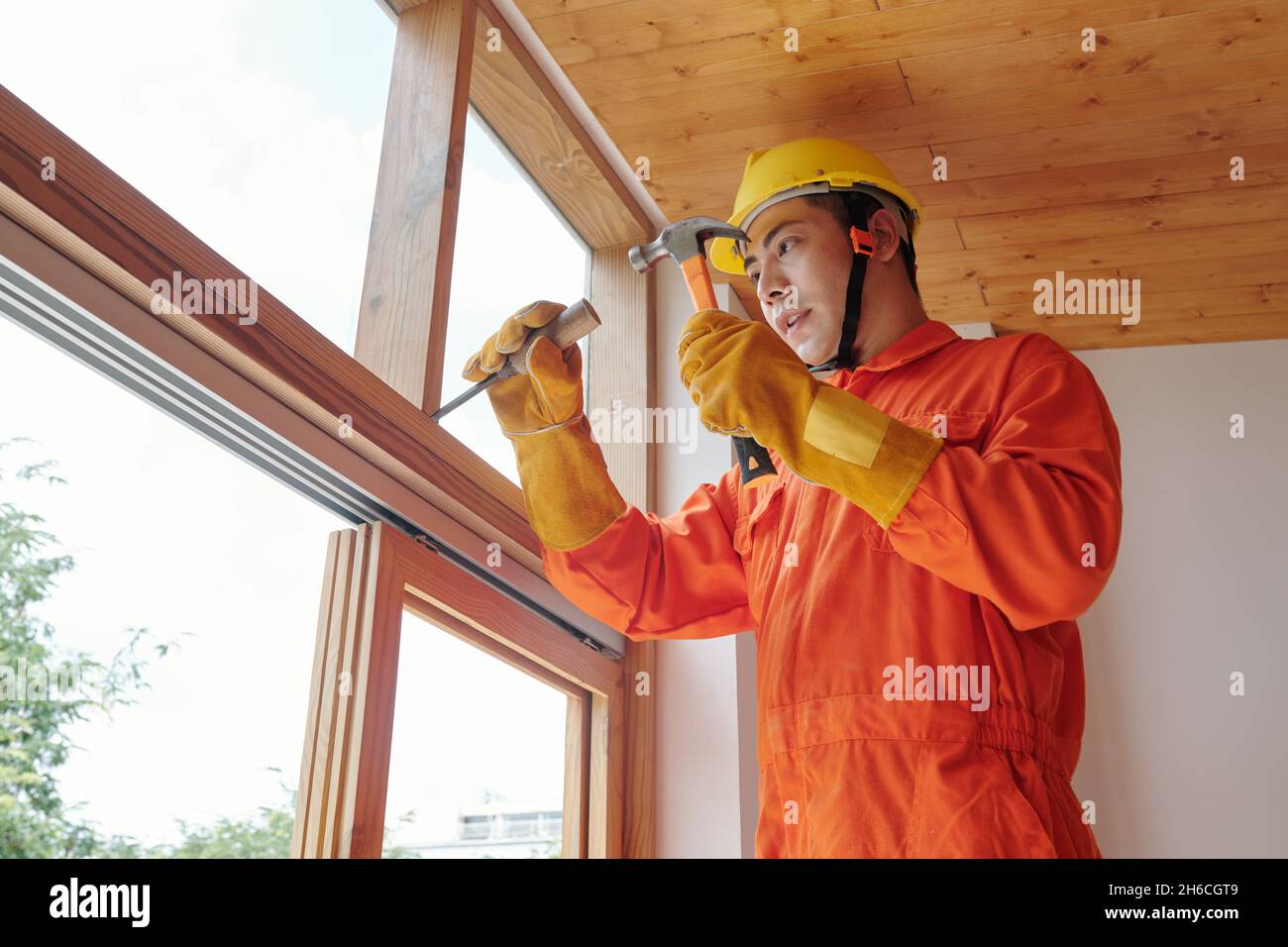 Construction worker with hammer and chisel removing old wooden window frame Stock Photo Alamy
