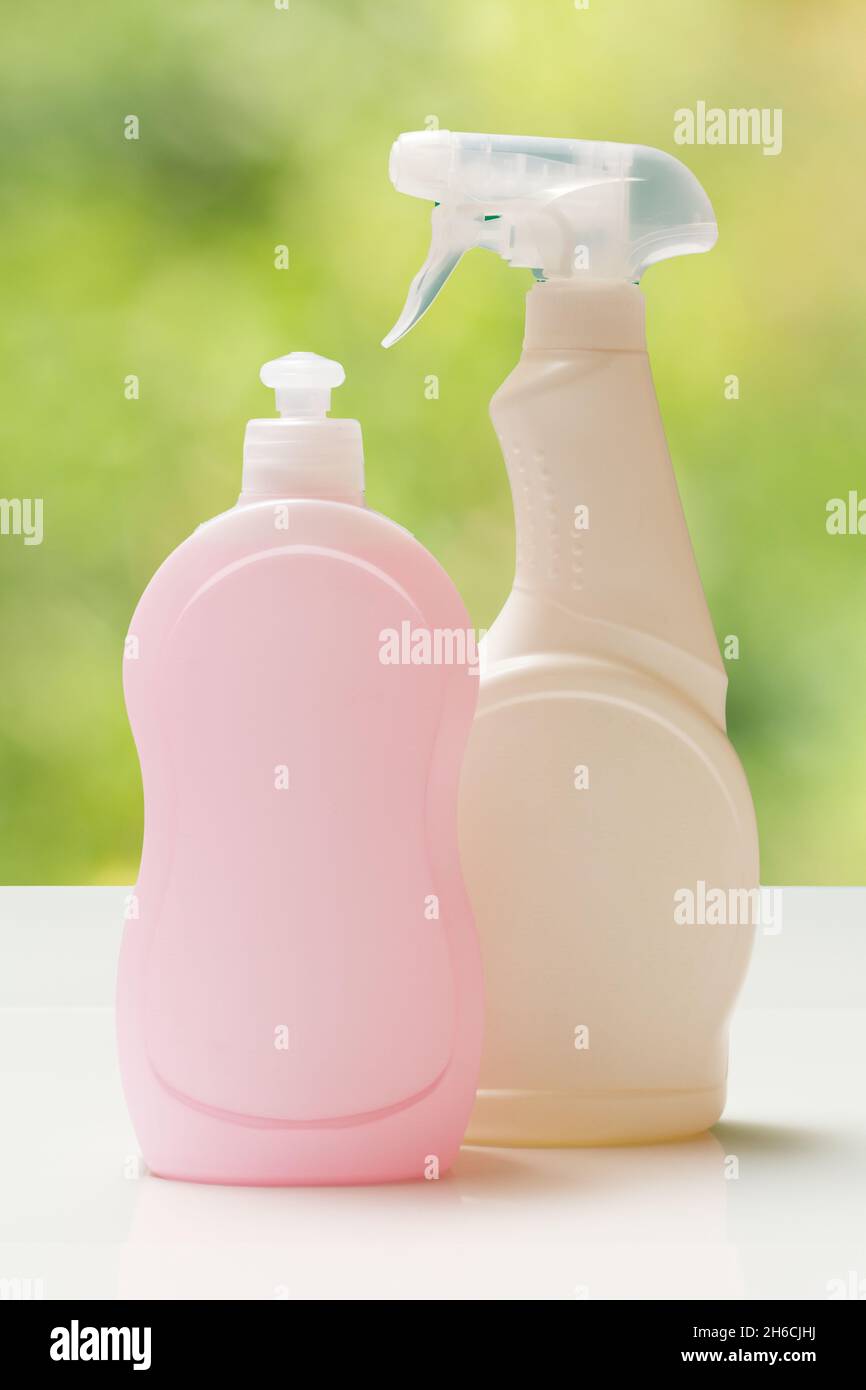 Plastic bottles of dishwashing liquid, glass cleaner on the blurred