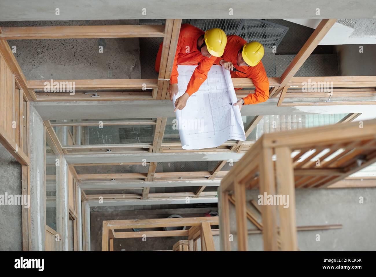 Construction workers discussing house plan and deciding what floor to