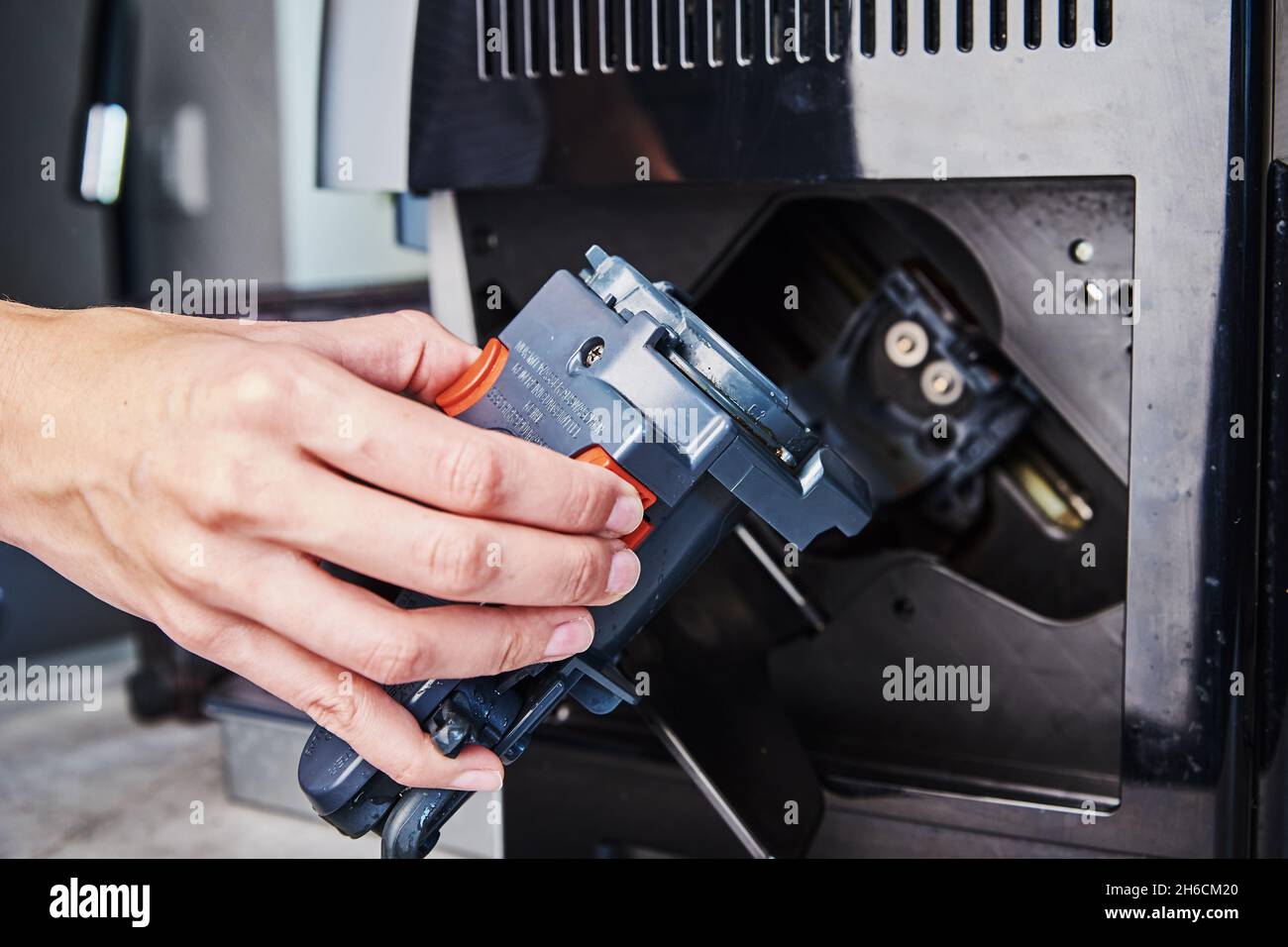 Automatic coffee machine cleaning. Woman inserts mechanism inside