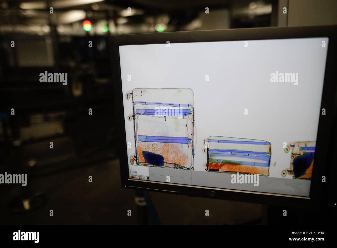 Shallow depth of field (selective focus) image with a screen showing luggages inside an x-ray scanning machine at an airport - airport security check. Stock Photo