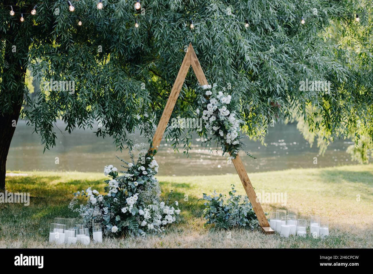 triangular wedding arch with white flowers Stock Photo