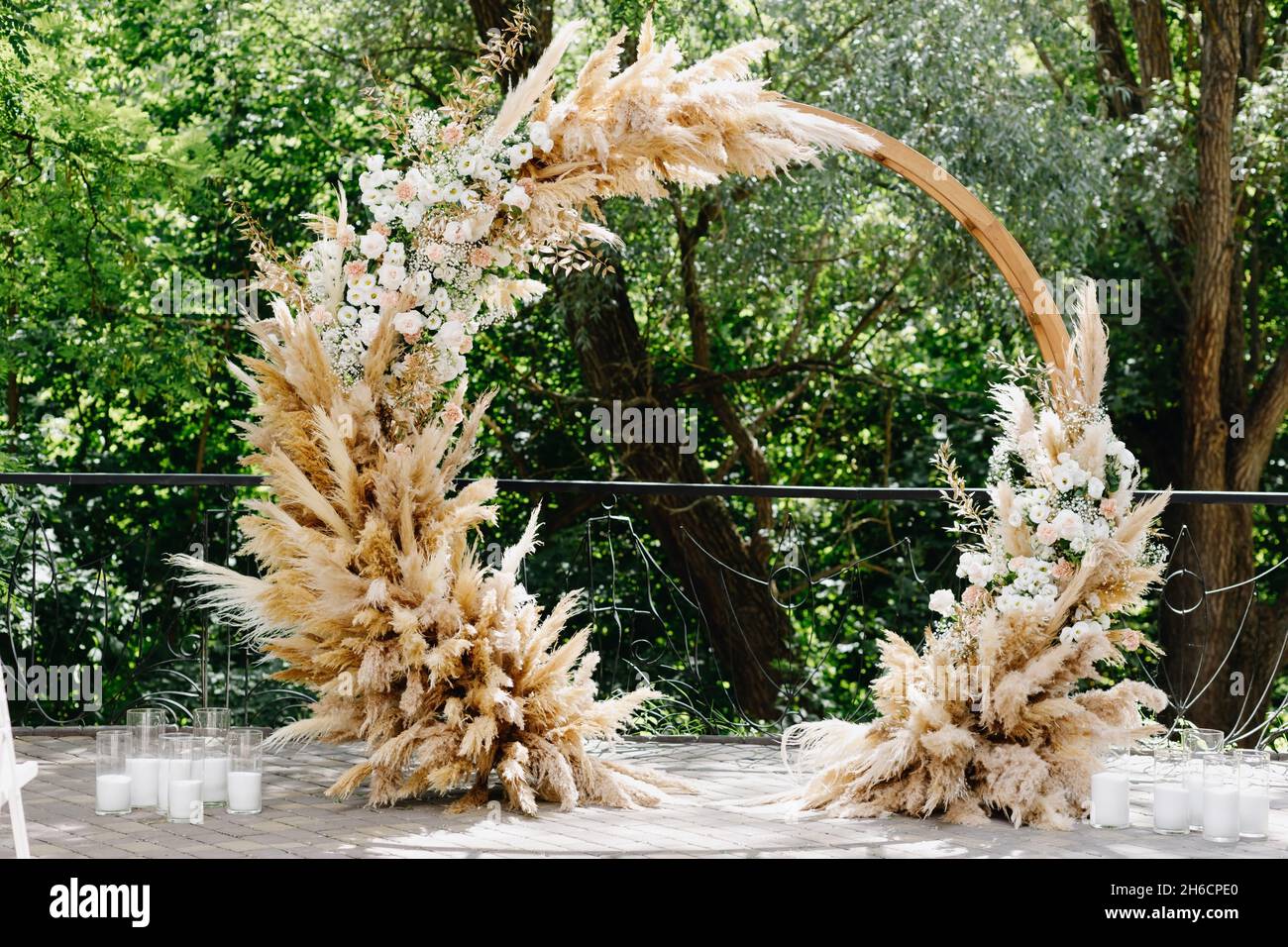 Round wedding arch on a background of greenery. Stock Photo