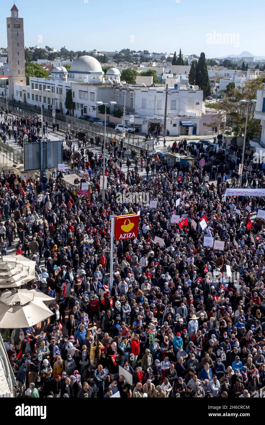 Tunis, Tunisia, November 14, 2021. Demonstrators carry flags and placards during a protest against Tunisian President Kais Saied's seizure of governing powers, in front of the parliament, in Tunis, Tunisia on November 14, 2021. Tunisian police have clashed with protesters near the chamber of the suspended parliament as demonstrators marched against President Kais Saied’s seizure of political power four months ago. Hundreds of police had blocked off the area where thousands of protesters were gathering on Sunday to demand that Saied restore the parliament and normal democratic rule. “Shut down  Stock Photo