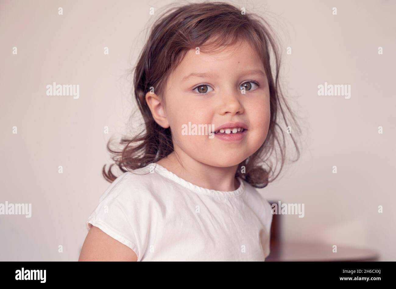 Close-up portrait of a cute little girl smiling - preschooler in a kindergarten Stock Photo