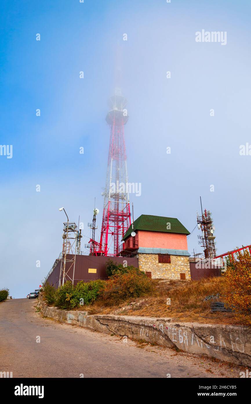 Cellular base station antenna tower in fog at the top of Mashuk mountain in Pyatigorsk city in Russia Stock Photo