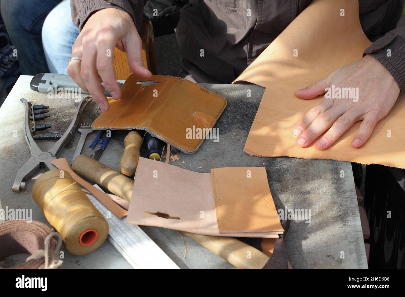 Handmade leather goods, craftsman at work in a workshop. Stock Photo