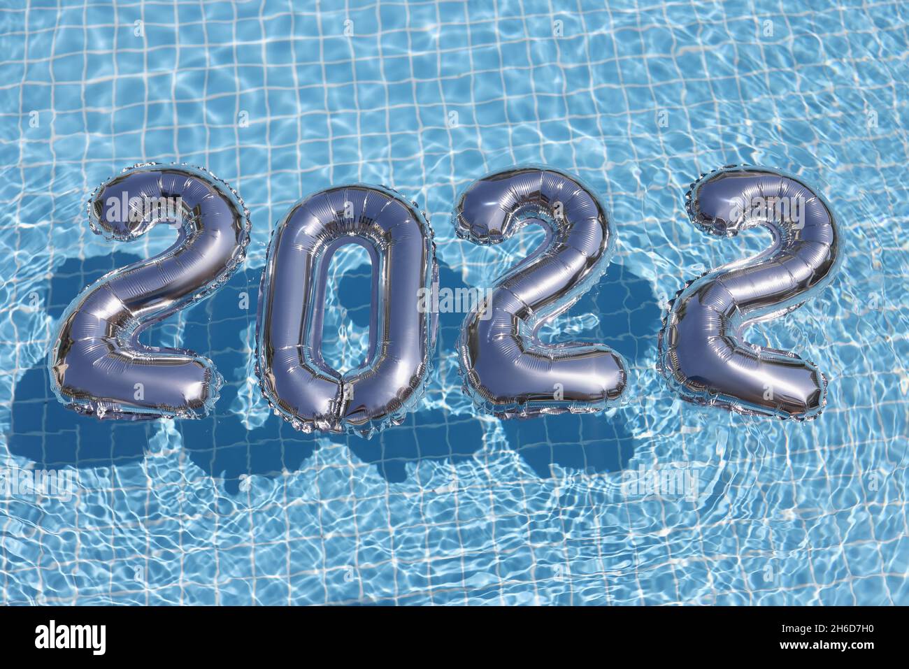 Foil silver numbers float on blue clean water of swimming pool Stock