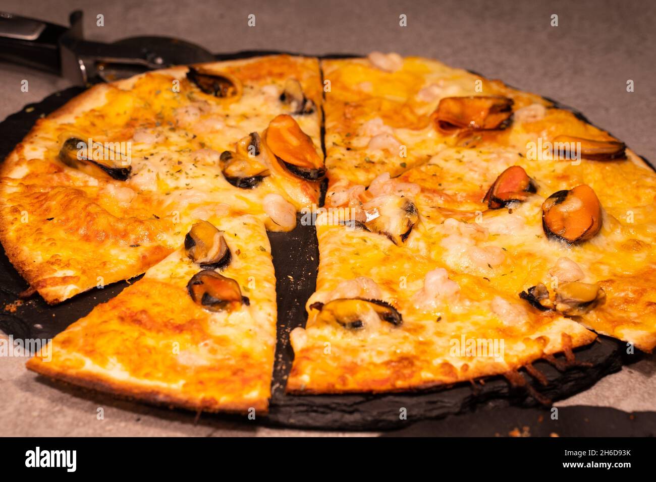 Delicious seafood pizza with mussels, ready to eat. Stock Photo