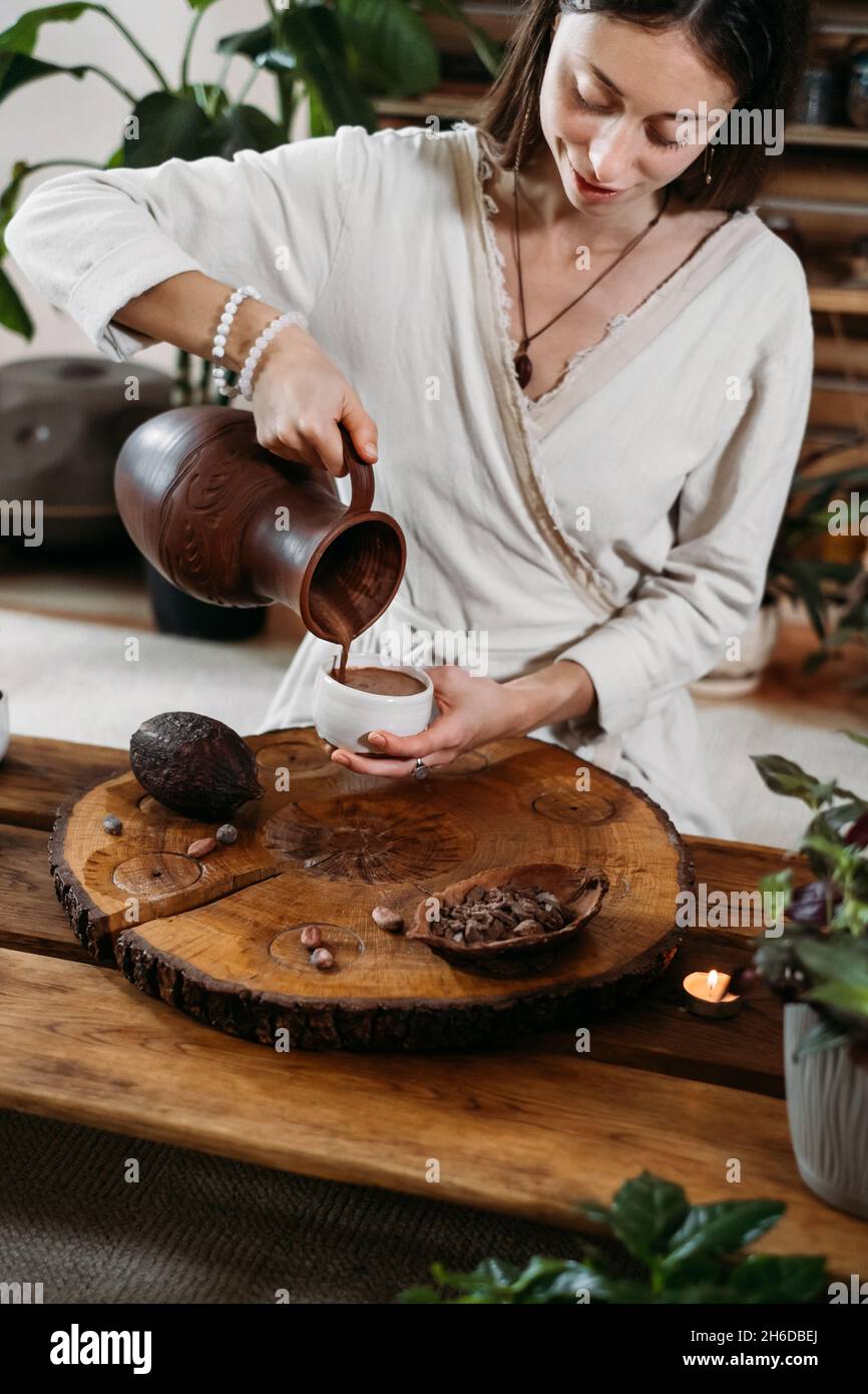 Cocoa Personal Ritual Cacao ceremony in atmospheric space with green plants and candles ...