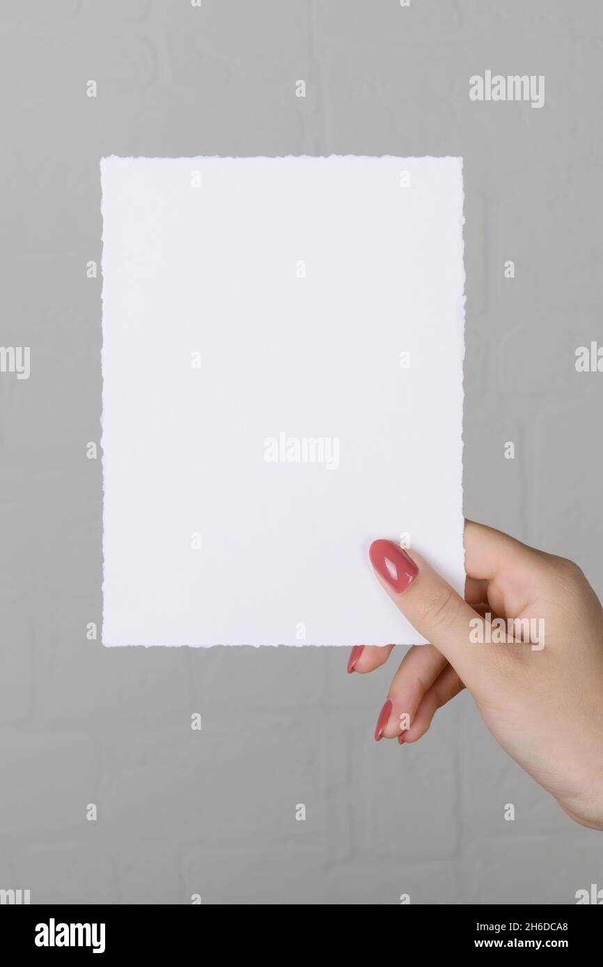 lose up of 5x7 ratio card white empty card mockup in female hand Stock Photo