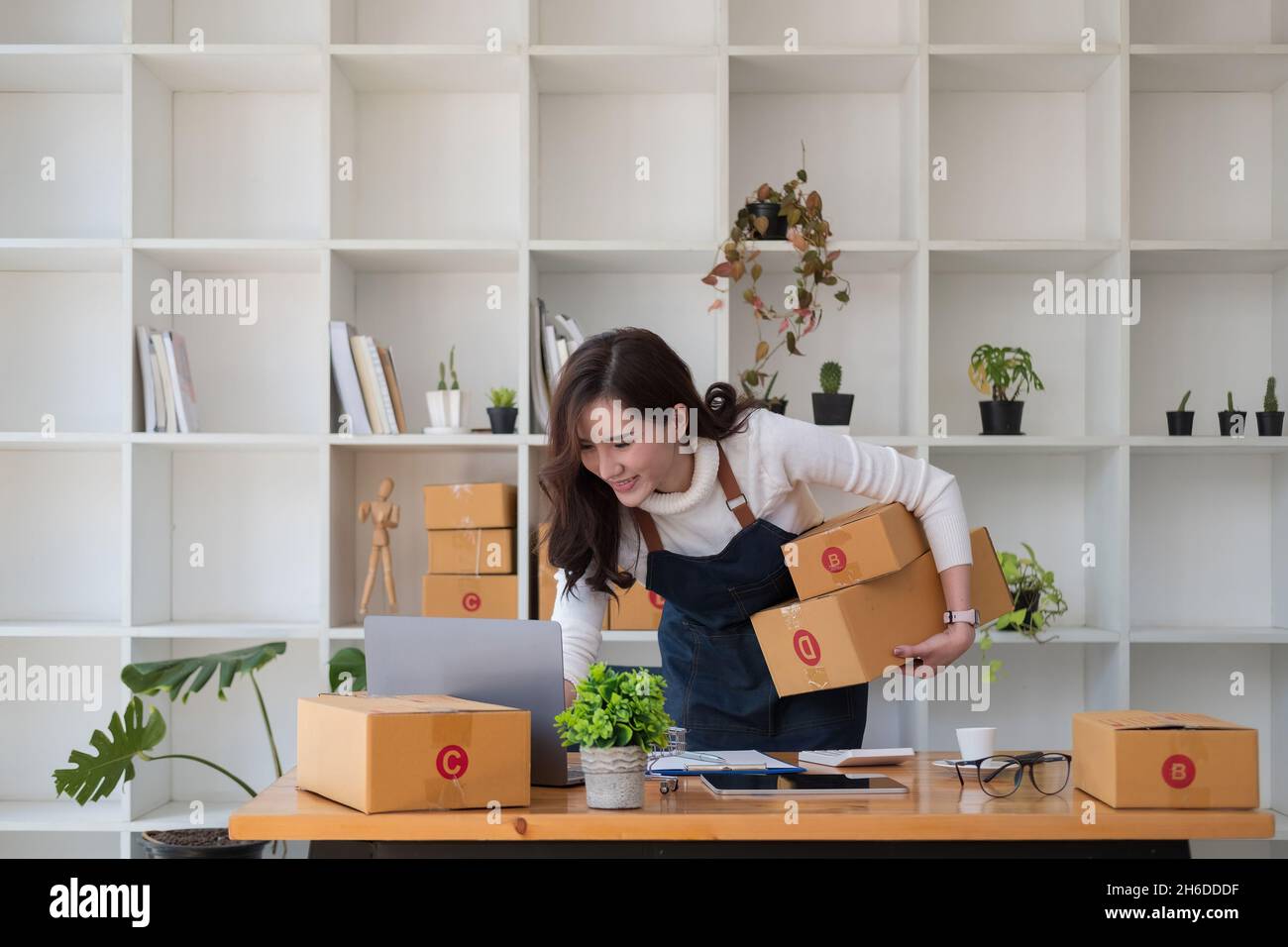 Starting Small business entrepreneur SME freelance,Portrait young woman working at home office, BOX,smartphone,laptop, online, marketing, packaging Stock Photo