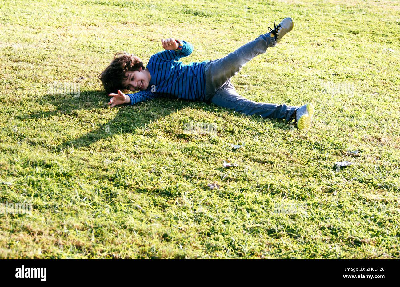 Kids Having Fun Rolling Down A Grassy Hill Stock Photo, Picture