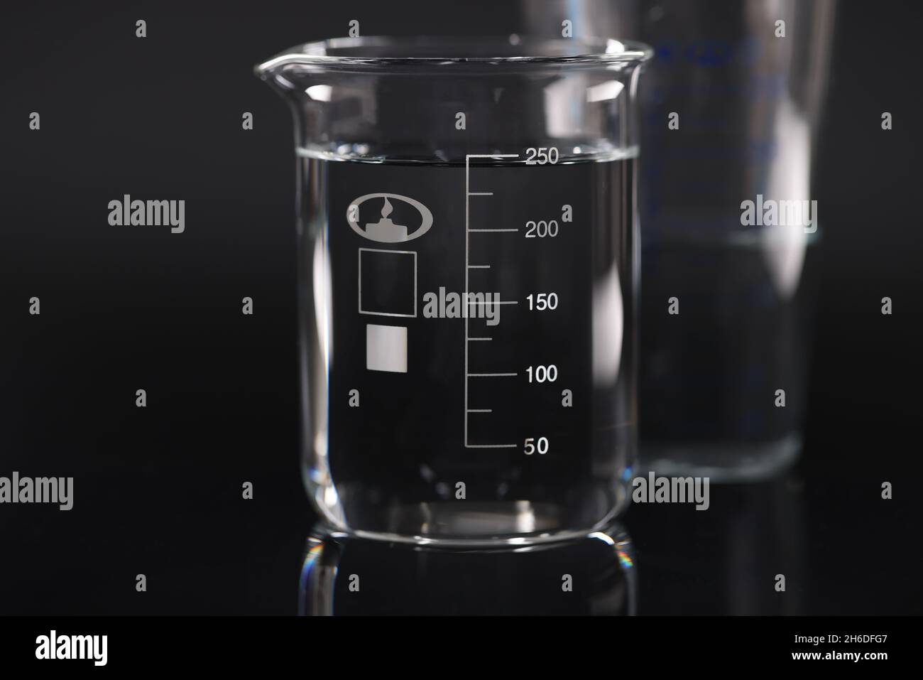 Closeup of chemical beaker with water on black background Stock Photo