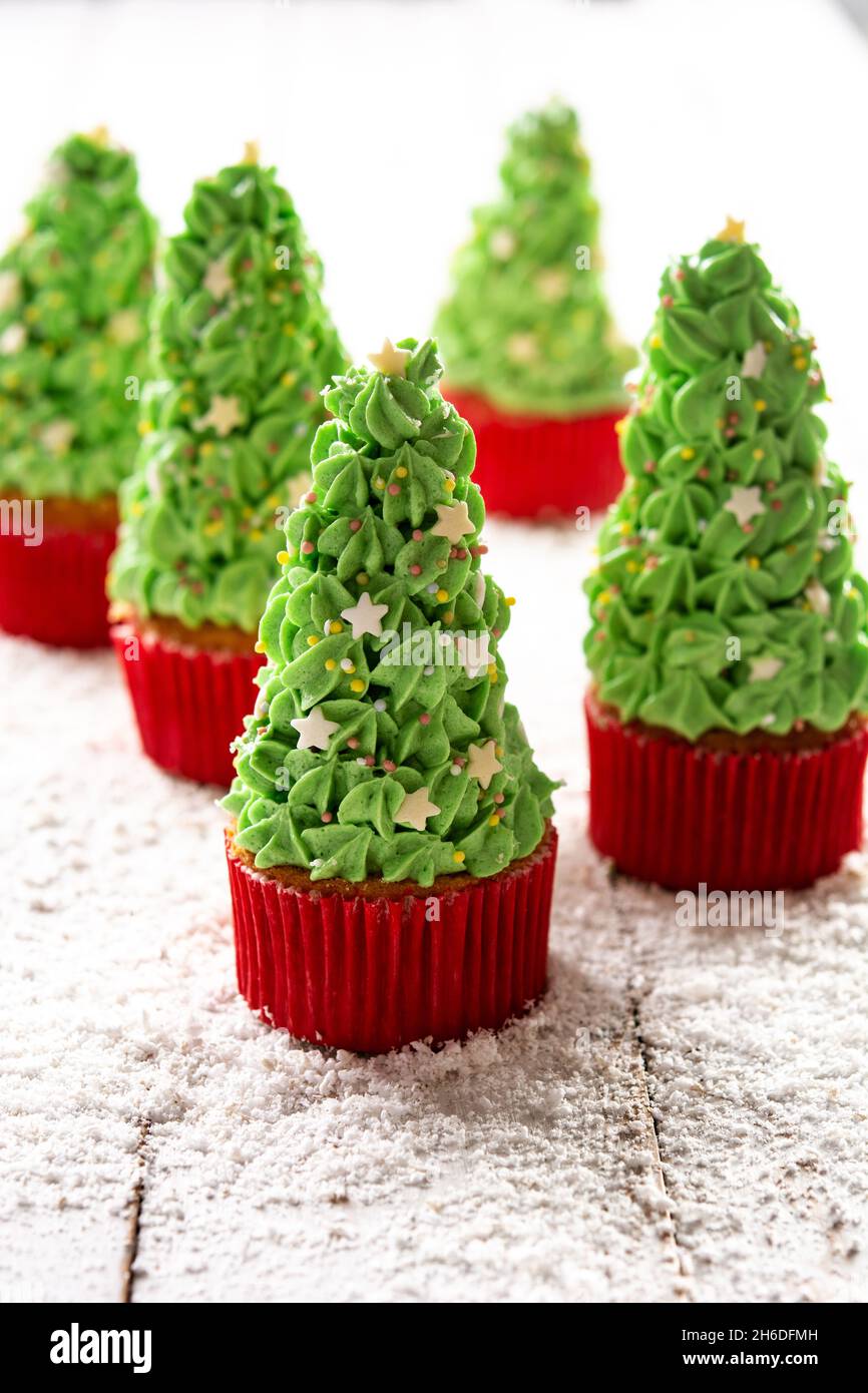 Christmas tree cupcakes on wooden table Stock Photo