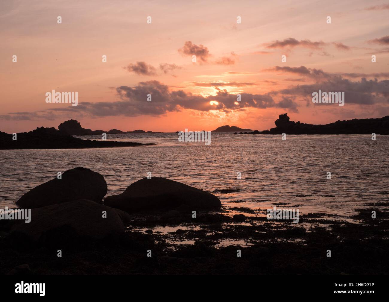 Sun setting over the rocks off Bryher, Isles of Scilly, viewed from Stony Par beach Stock Photo