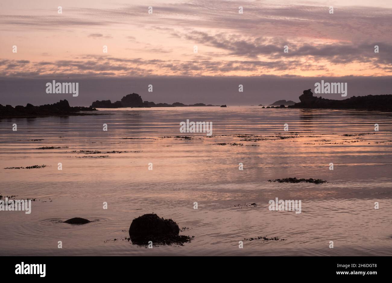 Sun setting over the rocks off Bryher, Isles of Scilly, viewed from Stony Par beach Stock Photo