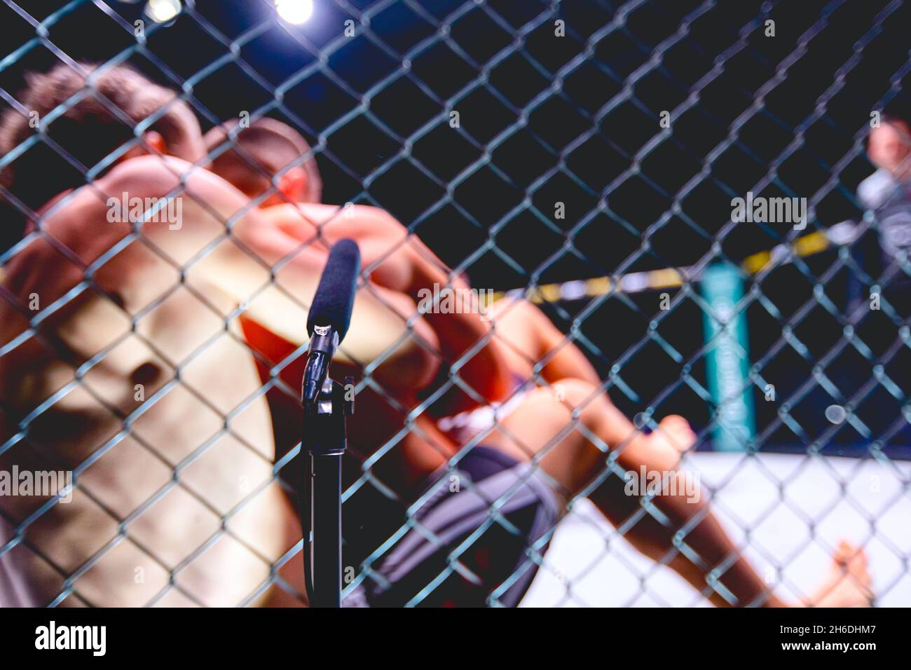 Professional microphone for radio, live broadcast MMA fight, fighters are  in clinch, wrestling in parterre on octagon floor Stock Photo - Alamy