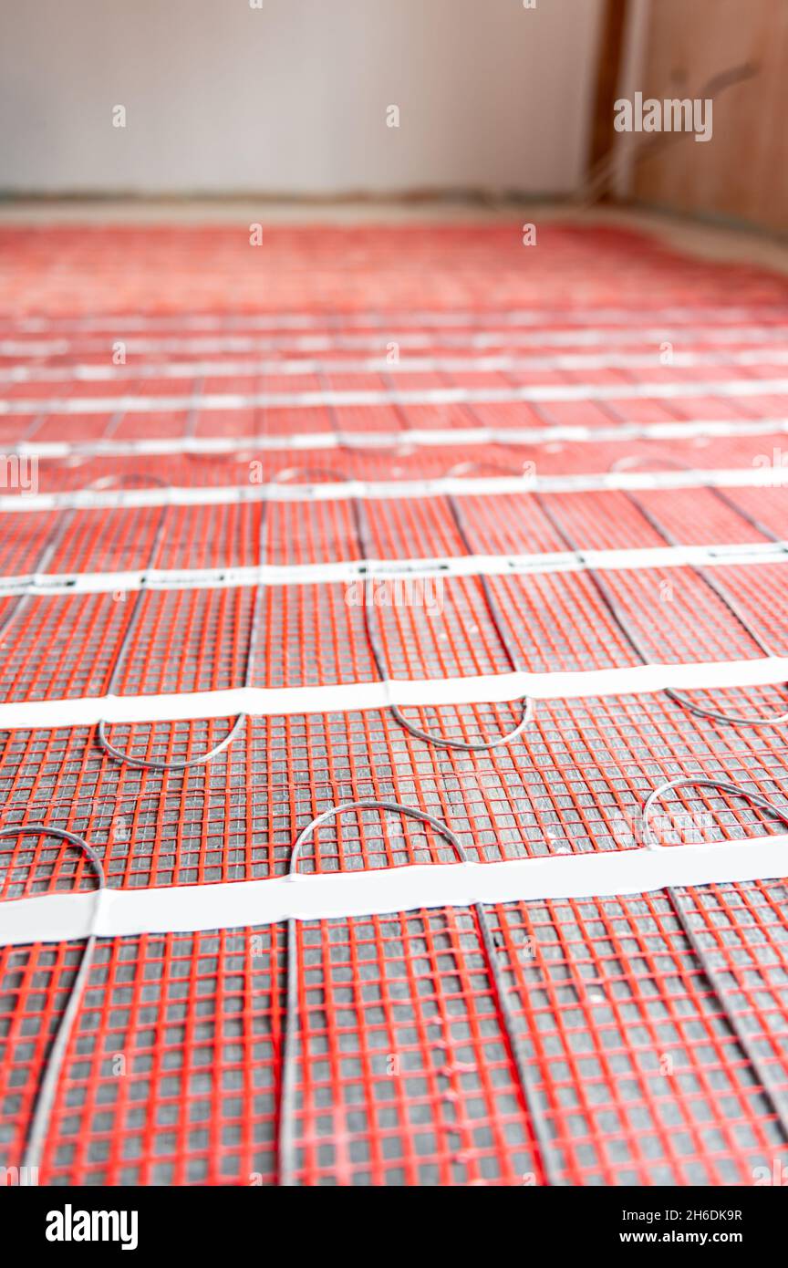 Process of instalation of electric underfloor heating mats Stock Photo