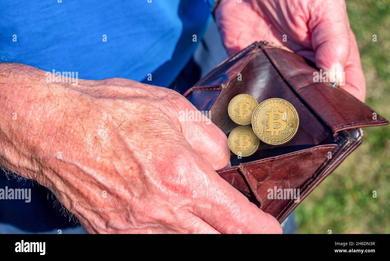 Old man holds wallet with bitcoins Stock Photo
