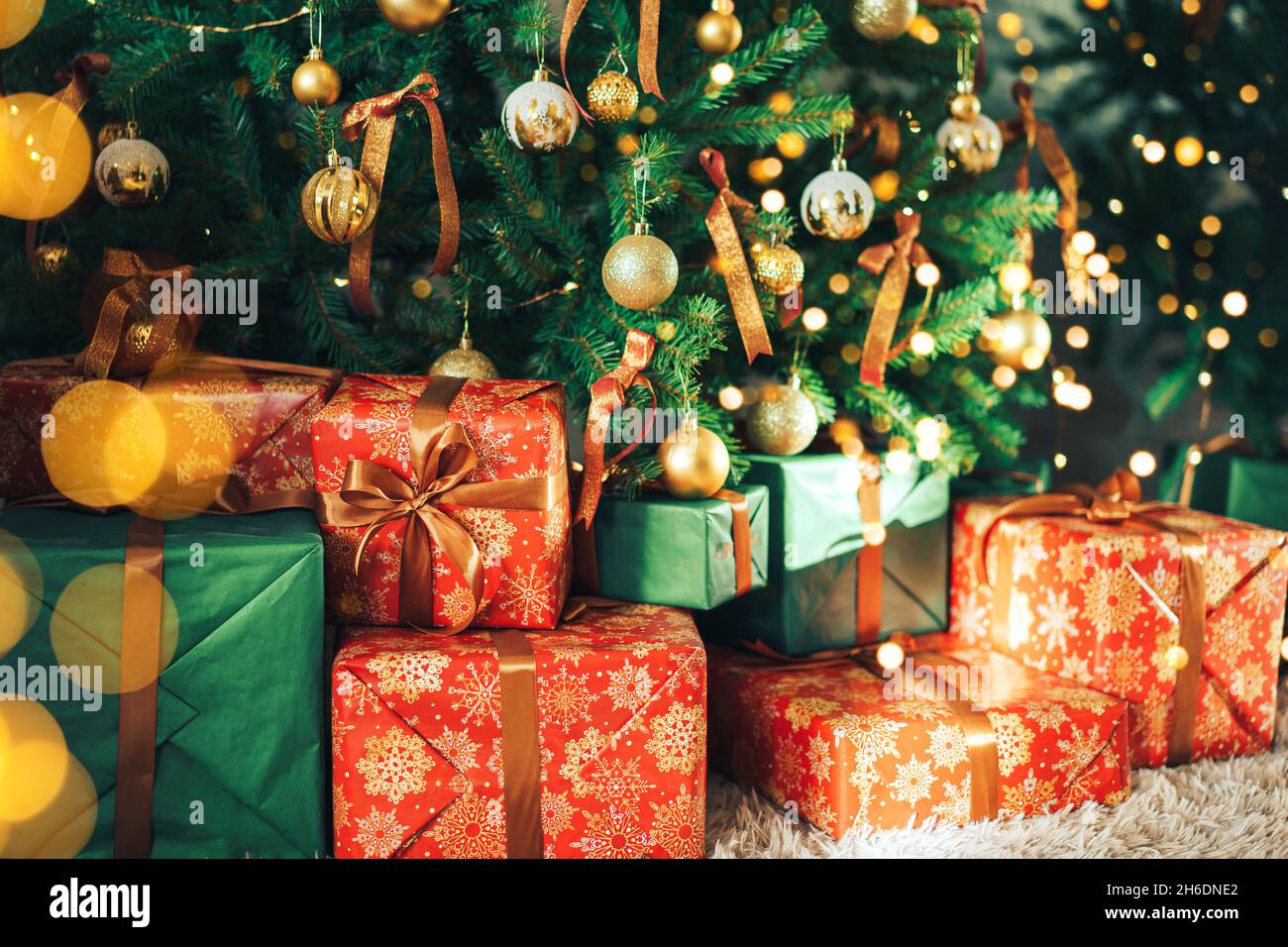 Many gift boxes standing under decorated Christmas tree Stock Photo