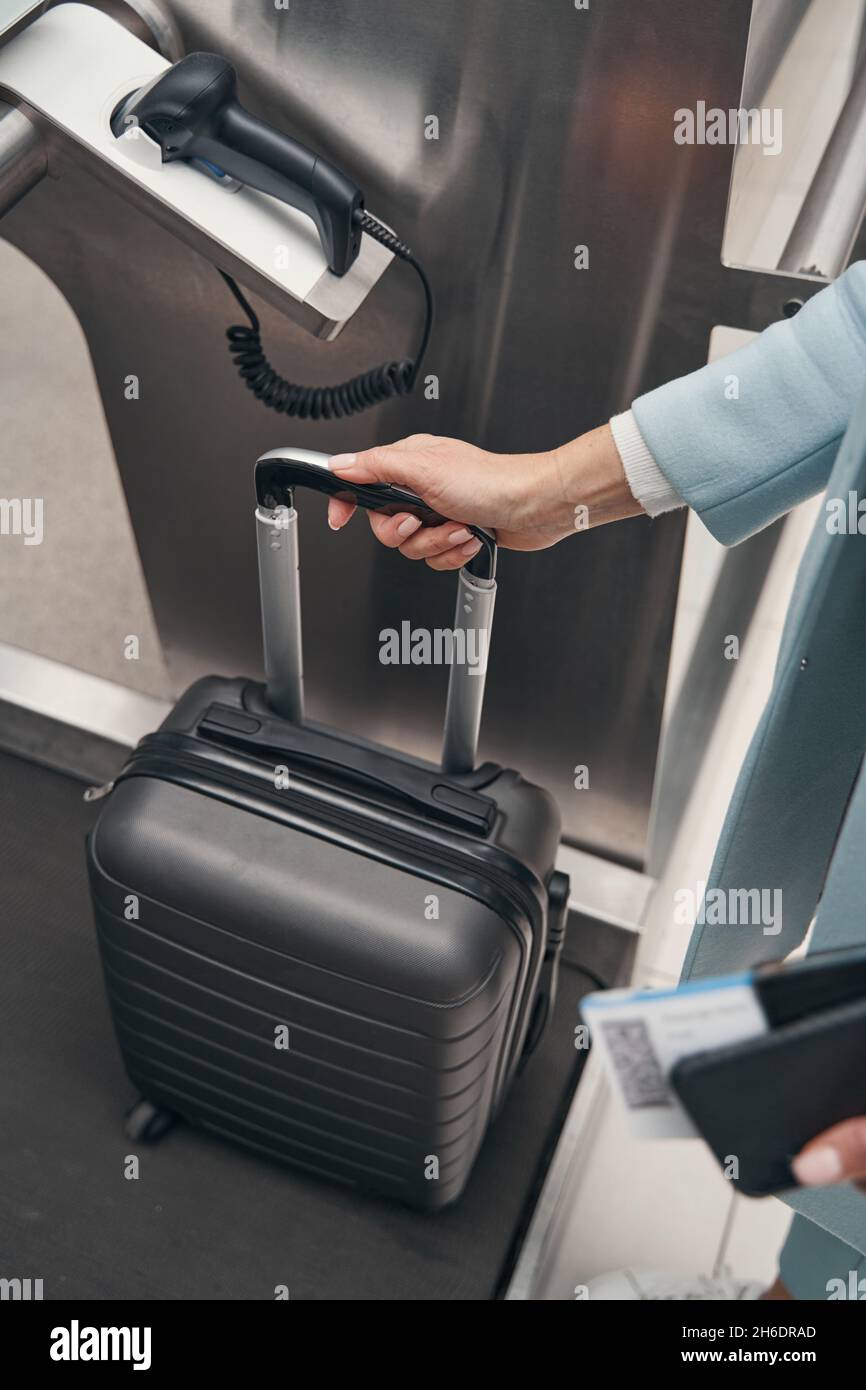 Caucasian woman using selfservice baggage dropoff unit Stock Photo