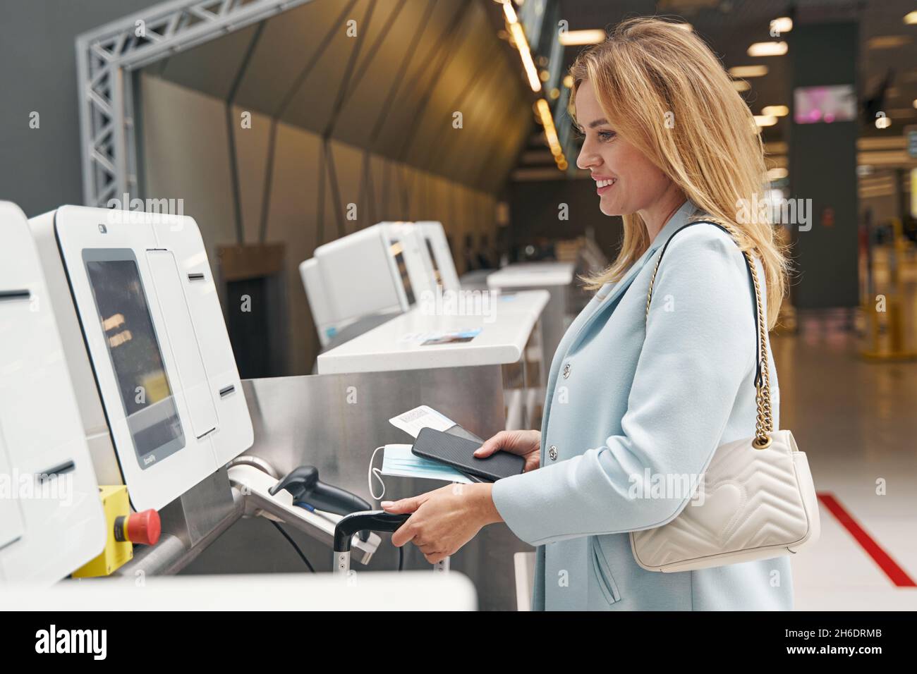 Smiling tourist checking in her baggage before flight Stock Photo Alamy