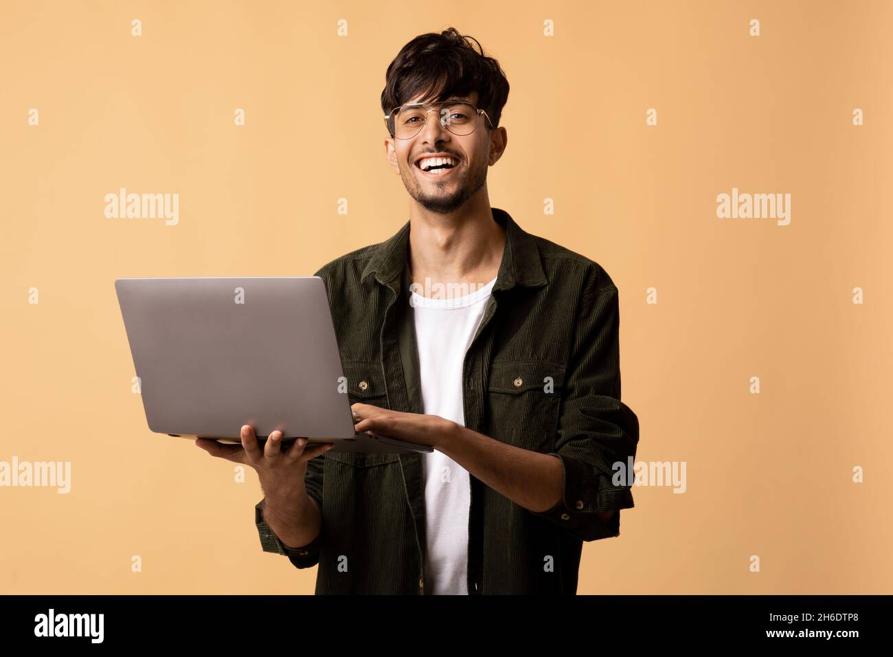 Happy indian guy freelancer using modern laptop, programming Stock Photo