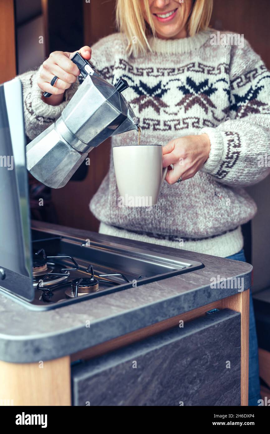 Woman serving coffee with coffee maker in camper van Stock Photo Alamy