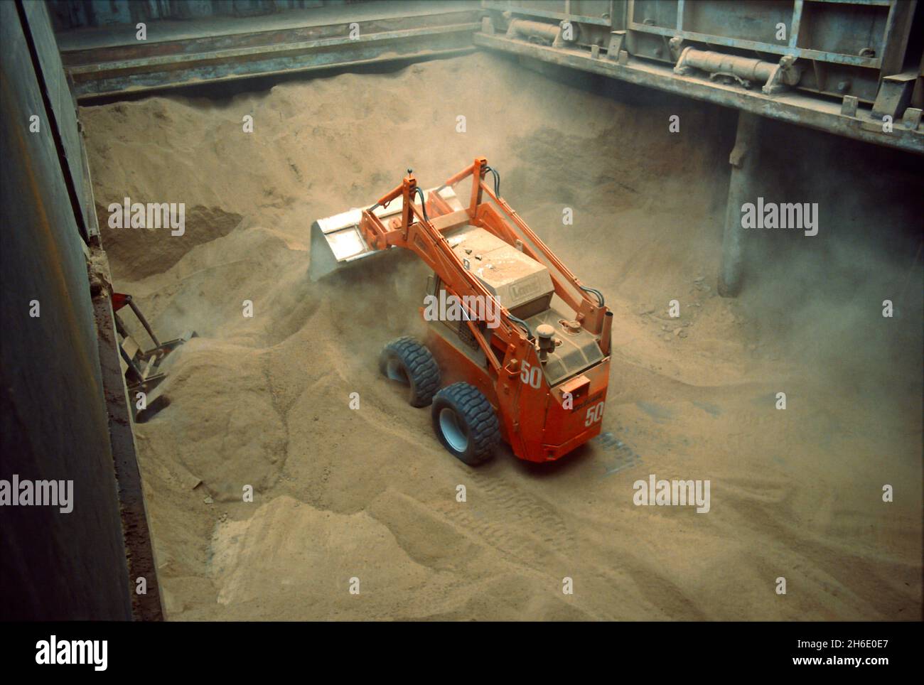 Feed cereals being  unloaded by means of a wheel-mounted front-end loader in the Port of Hamburg. Stock Photo