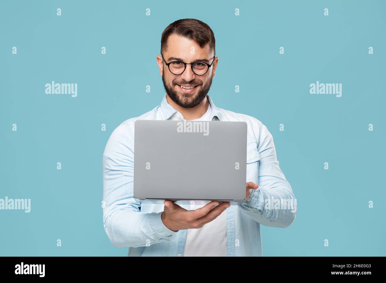 Happy adult european businessman in glasses working on laptop or making video call Stock Photo