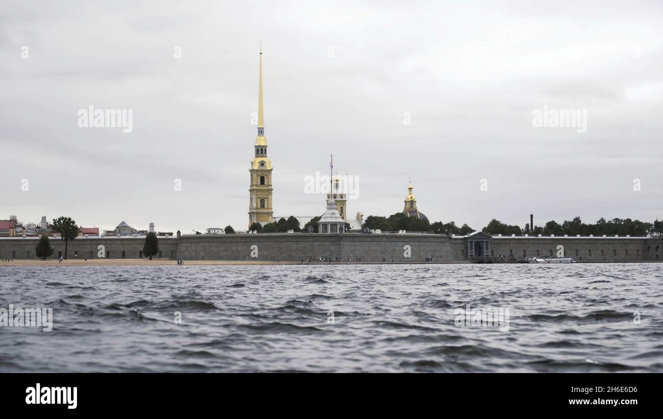 Close up of small waves of neva river and the golden spire of the Peter and Paul fortress. Cloudy sky above the Petropavlovskaya fortress and Neva riv Stock Photo