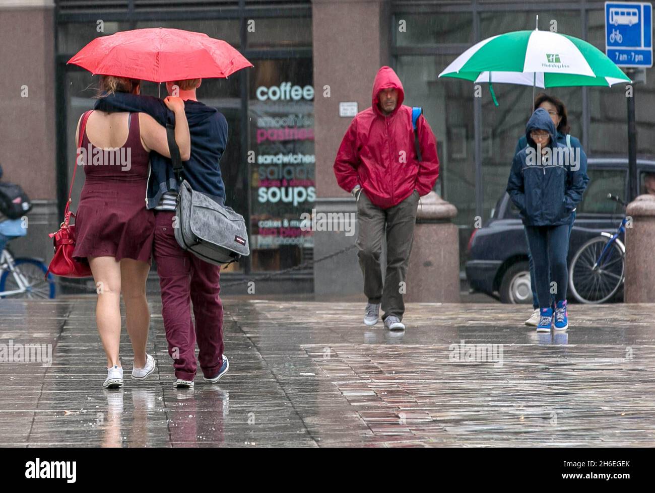 Office workers and tourists are pictured in the rain outside St Paul's ...