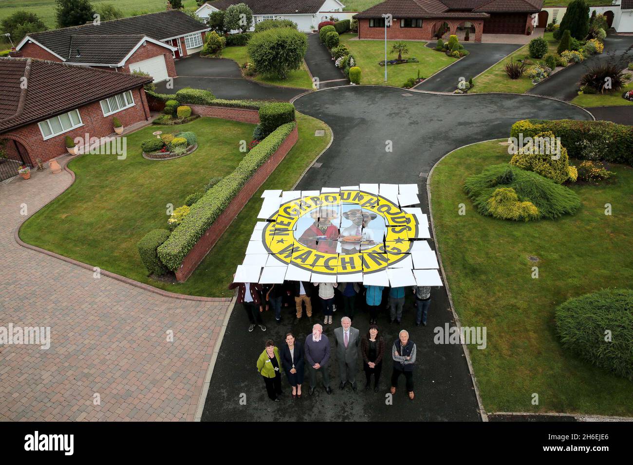 Chairman of Neighbourhood Watch, Jim Maddan and head of Home for comparethemarket.com, Helen Phipps, are joined by Liz Biddle, Home Watch Officer for Cheshire, Kate Daisly, Operations Director for Neighbourhood Watch, Mike Heathfield, Chairman, Parkgate Home Watch, Ray Symes, Village Coordinator for Helsby, and local residents in Wirral, Cheshire to reveal a special edition logo as the movement celebrates its 50th anniversary. The new image includes meerkat favourites Aleksandr and Sergie in a bid to attract a younger audience. Wirral is home to one of the first Neighbourhood Watch schemes in  Stock Photo