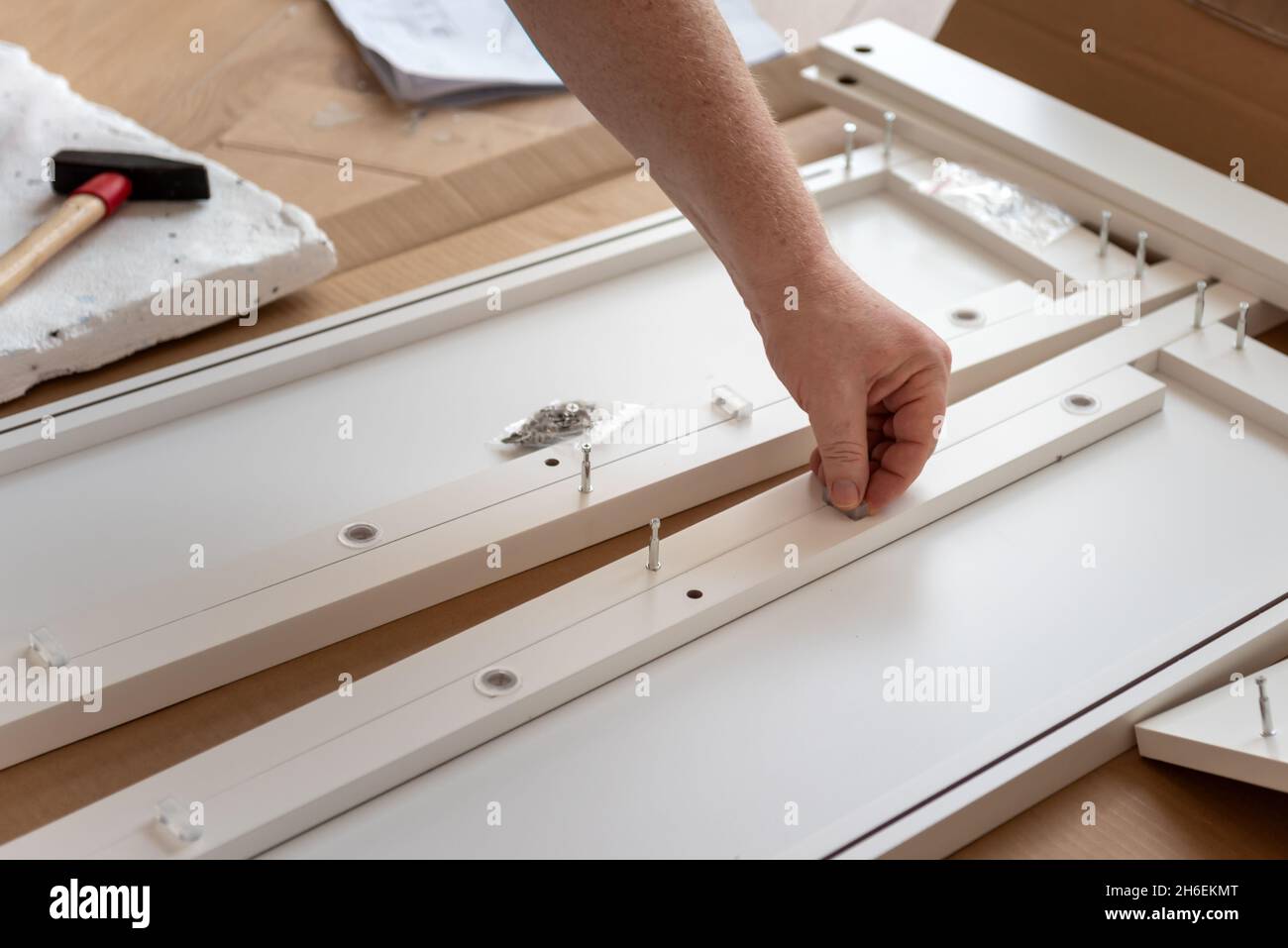 Man putting together self assembly furniture In new home Stock Photo