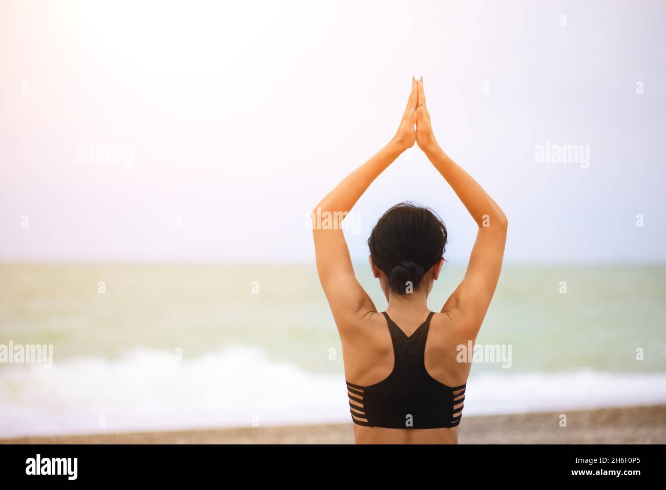 Back view portrait of woman stretching her arms up. Stock Photo