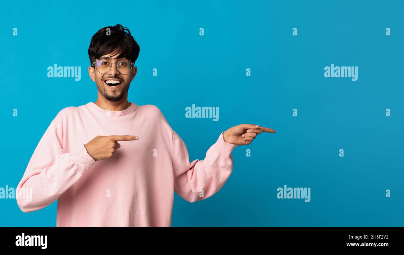 Excited middle eastern man pointing at copy space Stock Photo