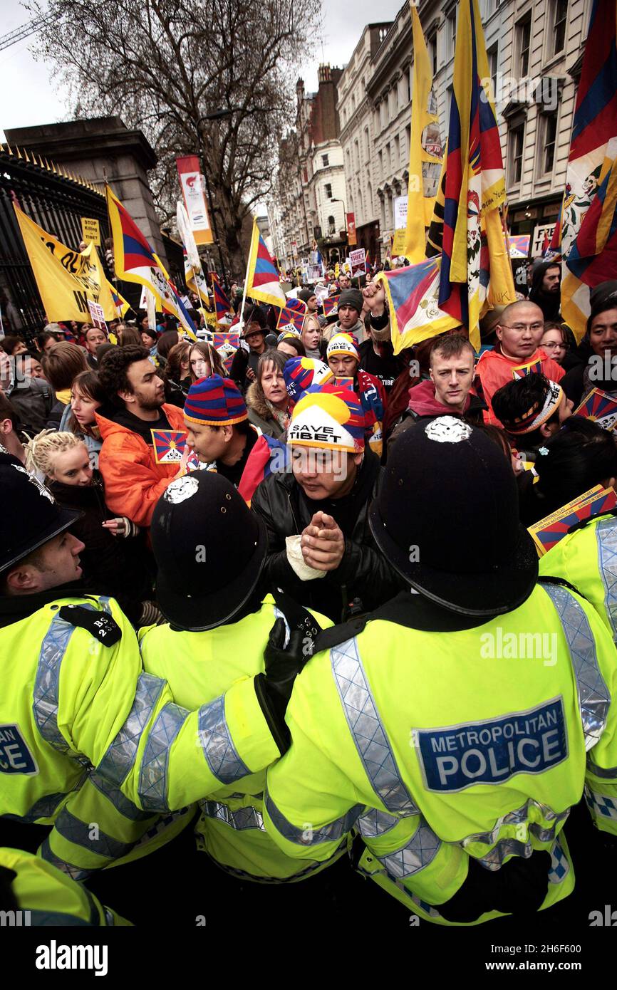 Tibetan protestors are held back by police after the Olympic torch passed by the British Museum in central London. Stock Photo