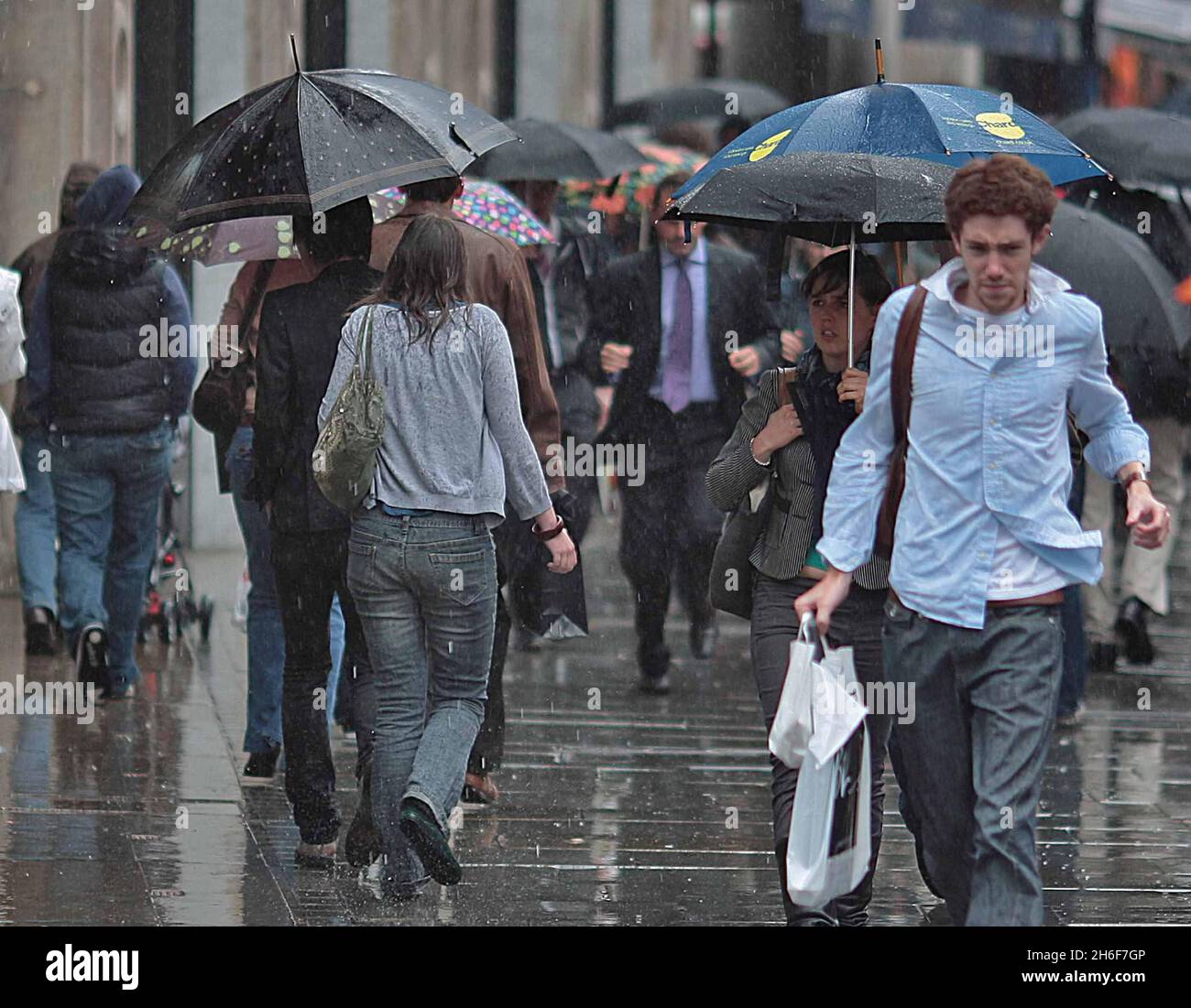 Shoppers on Regent's Street brave the bad weather as heavy rain falls on London Stock Photo Alamy