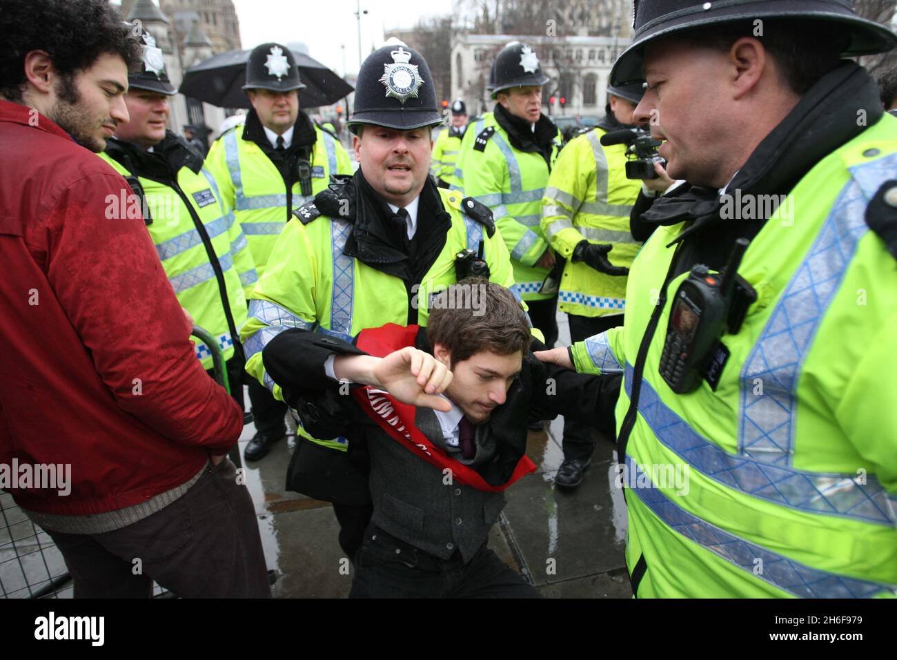 A protester is taken away by the police during a demonstration where protesters chained themselves to the railings of the House of Commons in London in demonstration against the proposed third runway at Heathrow Airport. Stock Photo