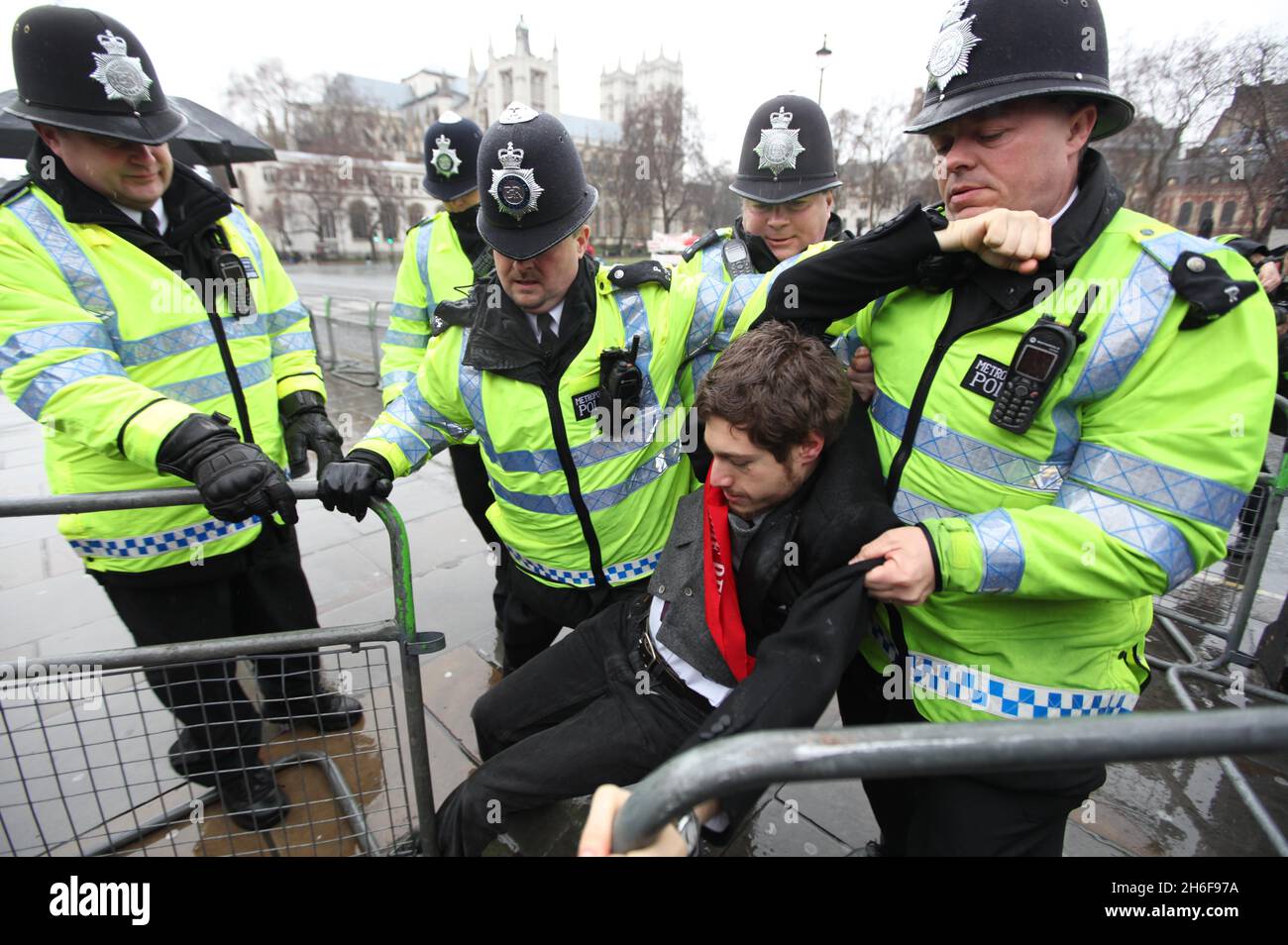 A protester is taken away by the police during a demonstration where protesters chained themselves to the railings of the House of Commons in London in demonstration against the proposed third runway at Heathrow Airport. Stock Photo