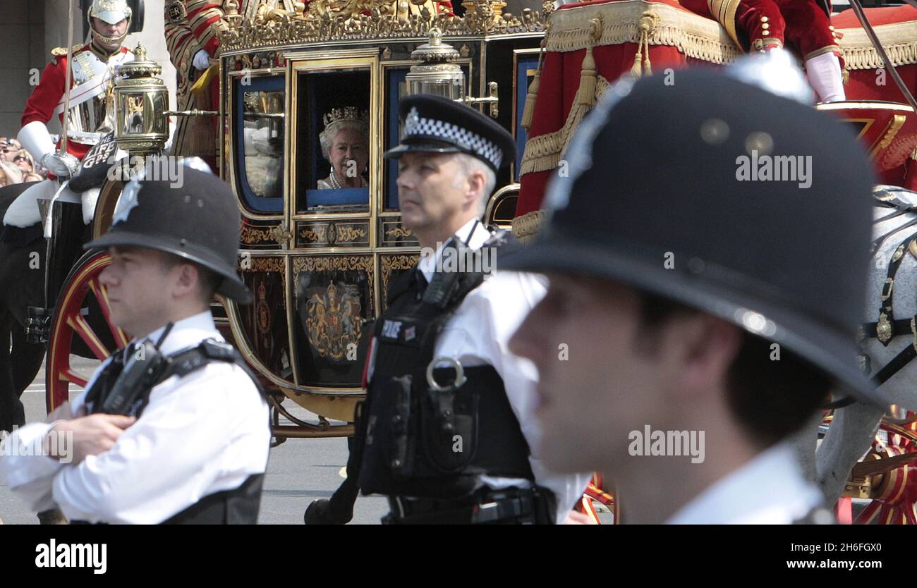 The Queen arrives among police officers in Westminster for the State Opening Of Parliament. Stock Photo